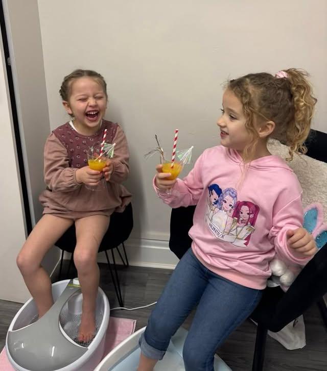 Girls laughing together during a foot spa pamper session