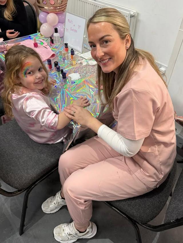 Girl in a pink robe at the nail and foot spa station with balloons