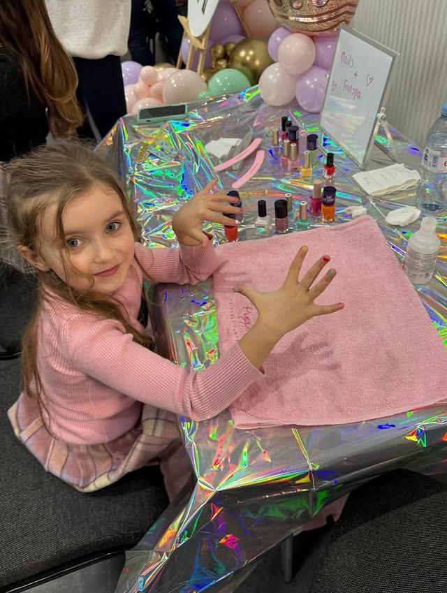 Girl proudly showing her colourful manicure at the pamper station