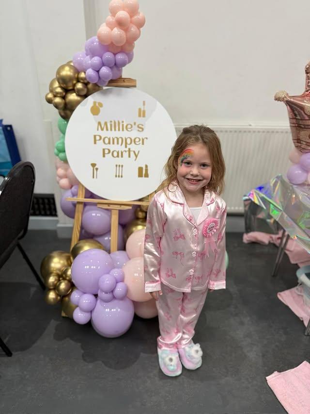 Birthday girl in pink satin pyjamas at her pamper party