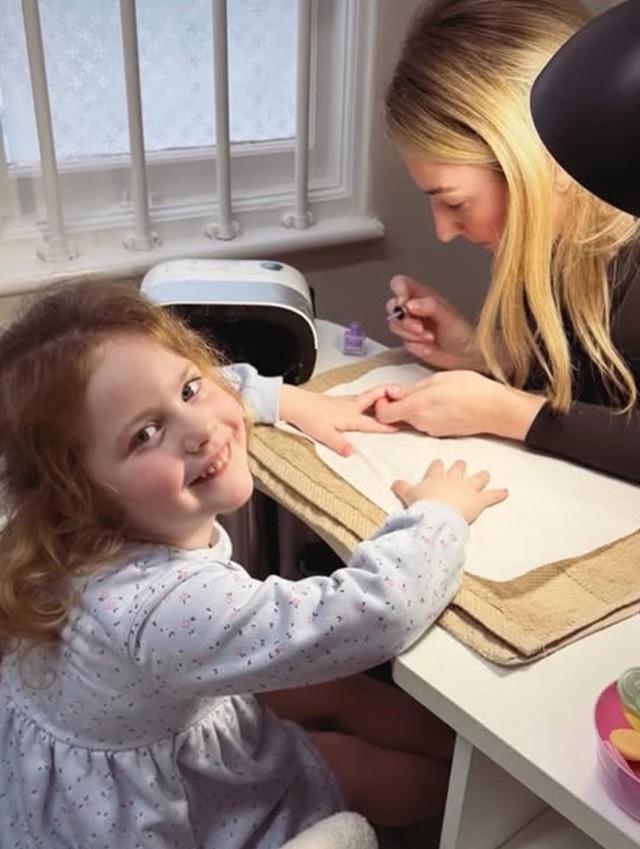 Young girl smiling during a mini manicure at a pamper party